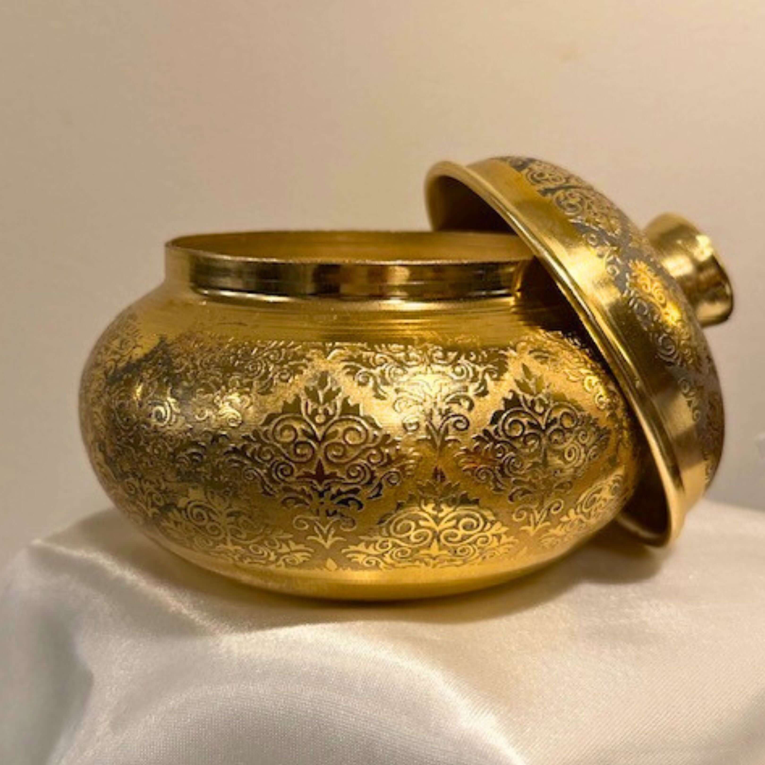 Elegant golden jar with intricate floral engravings, perfect for storage or decor.