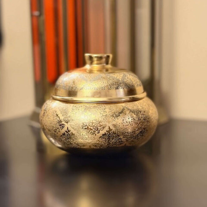 Elegant engraved candle jar with a gold and silver floral design, perfect for enhancing home decor.