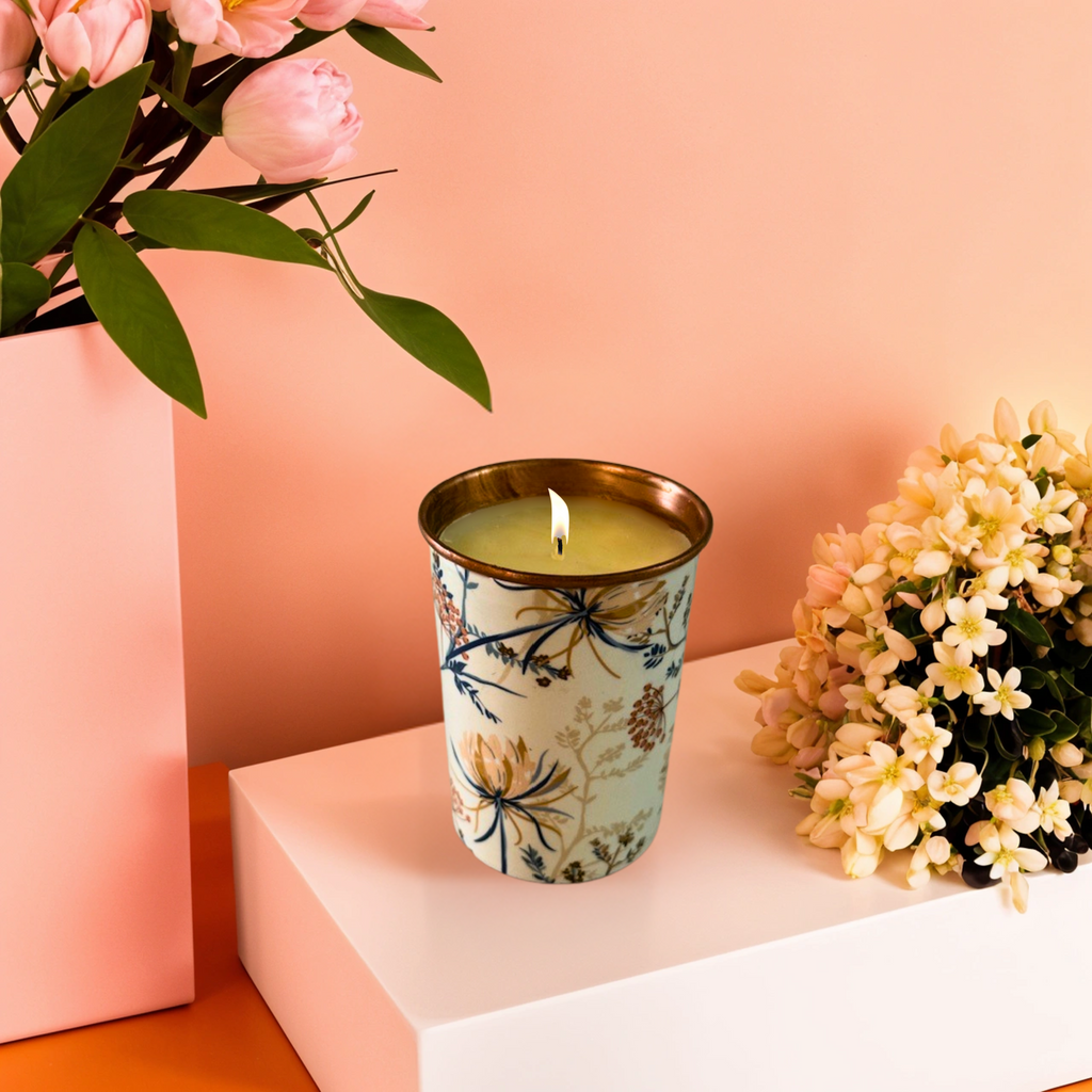 Decorative candle in a floral container with flowers on a pink background