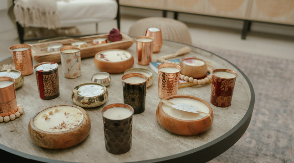 Table with various candles and decorative items in a cozy indoor setting